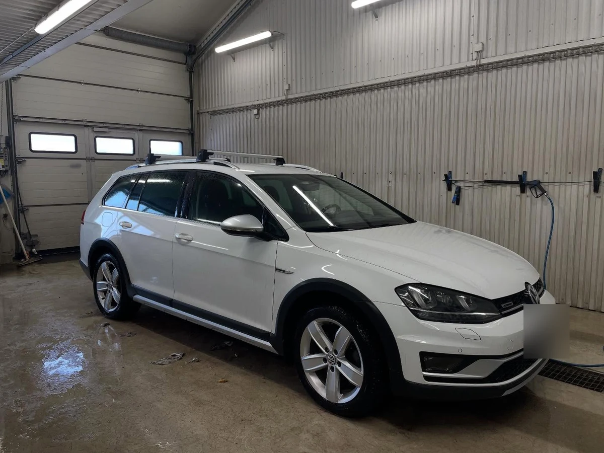 Vit Volkswagen Golf Alltrack efter rekond, fotograferad snett framifrån